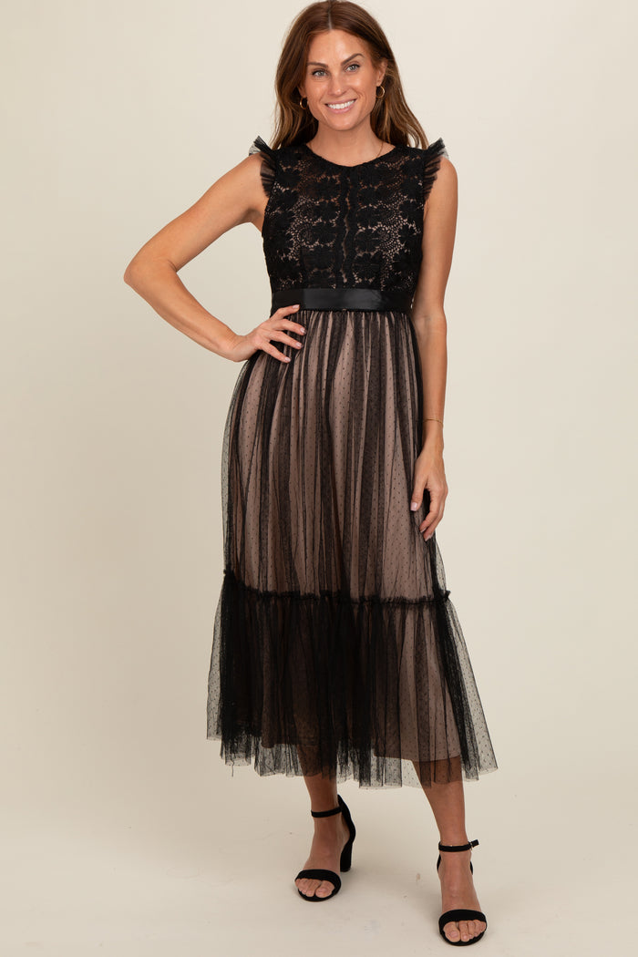 woman wearing a black lace and tulle maxi dress with a fitted bodice and tiered skirt