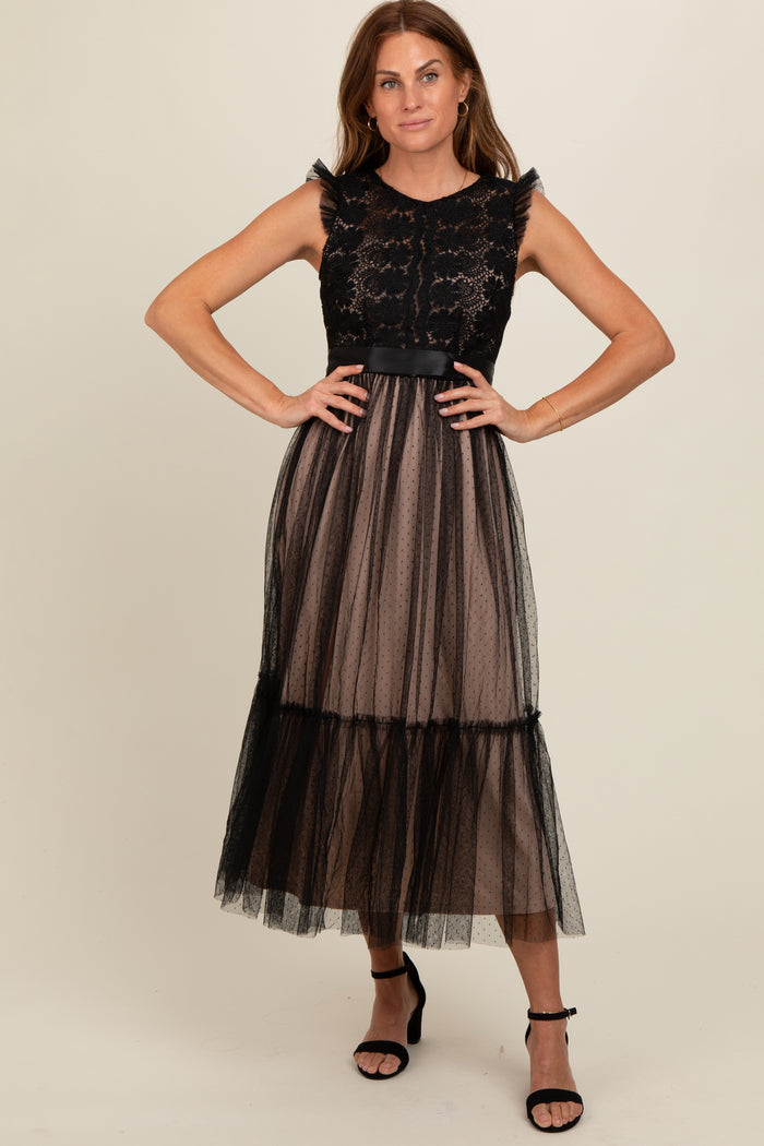 woman wearing a black lace and tulle midi dress with sheer overlay and ruffled sleeves