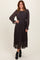 woman wearing a dark floral long sleeve pleated dress with a cinched waist and black ankle boots