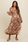 woman wearing a brown floral maternity maxi dress with long sleeves and a smocked bodice