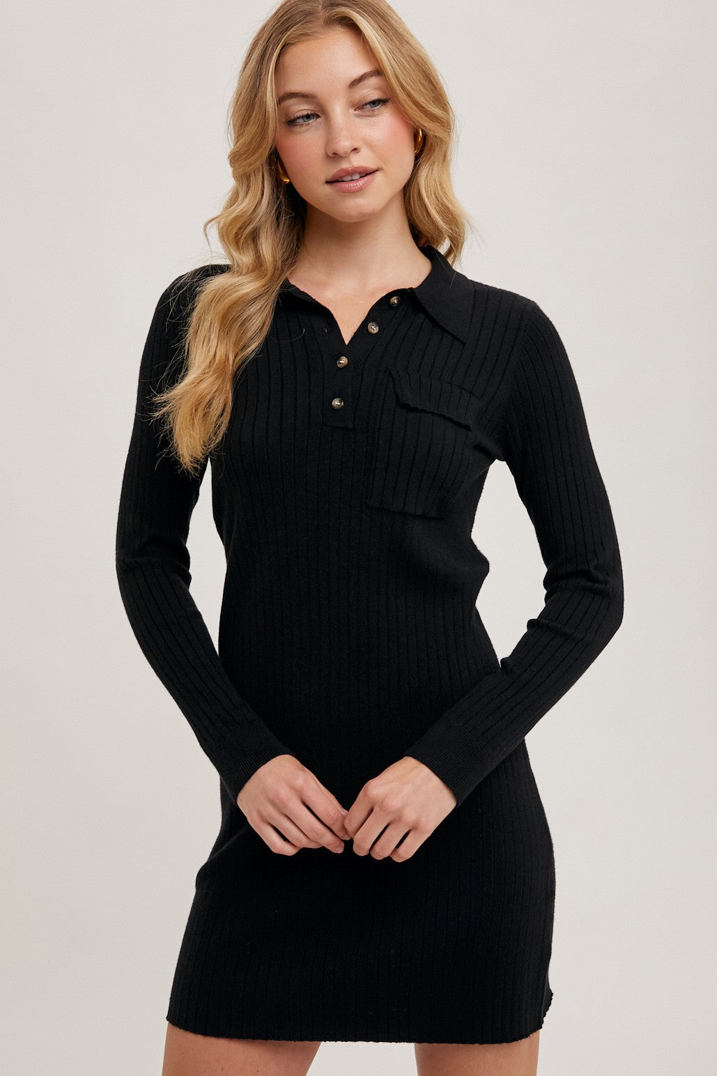 woman wearing a black ribbed long sleeve dress with a collared neckline and button detail