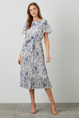 woman wearing a floral pleated midi dress in blue and white with short sleeves and a tie waist