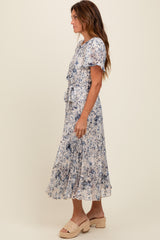 woman wearing a blue and white floral midi dress with short sleeves and a waist tie