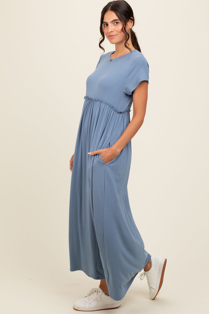 woman wearing a blue short sleeve maxi dress with an elastic waist and pockets, styled with white sneakers