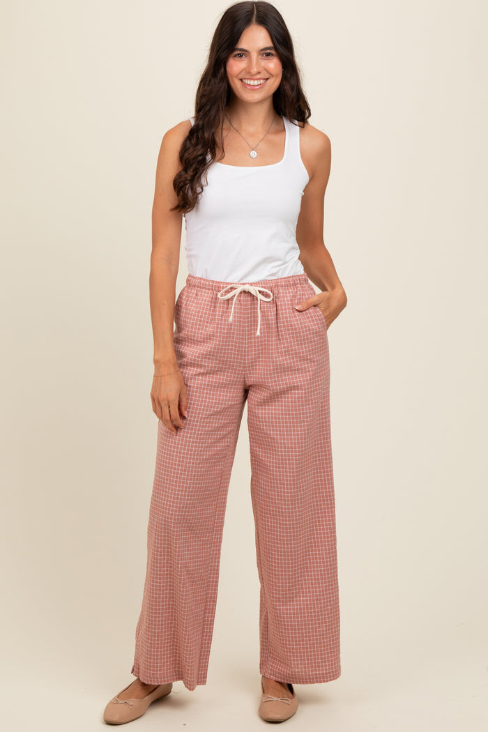 woman wearing a white tank top and pink gingham wide-leg pants with drawstring waist and pockets