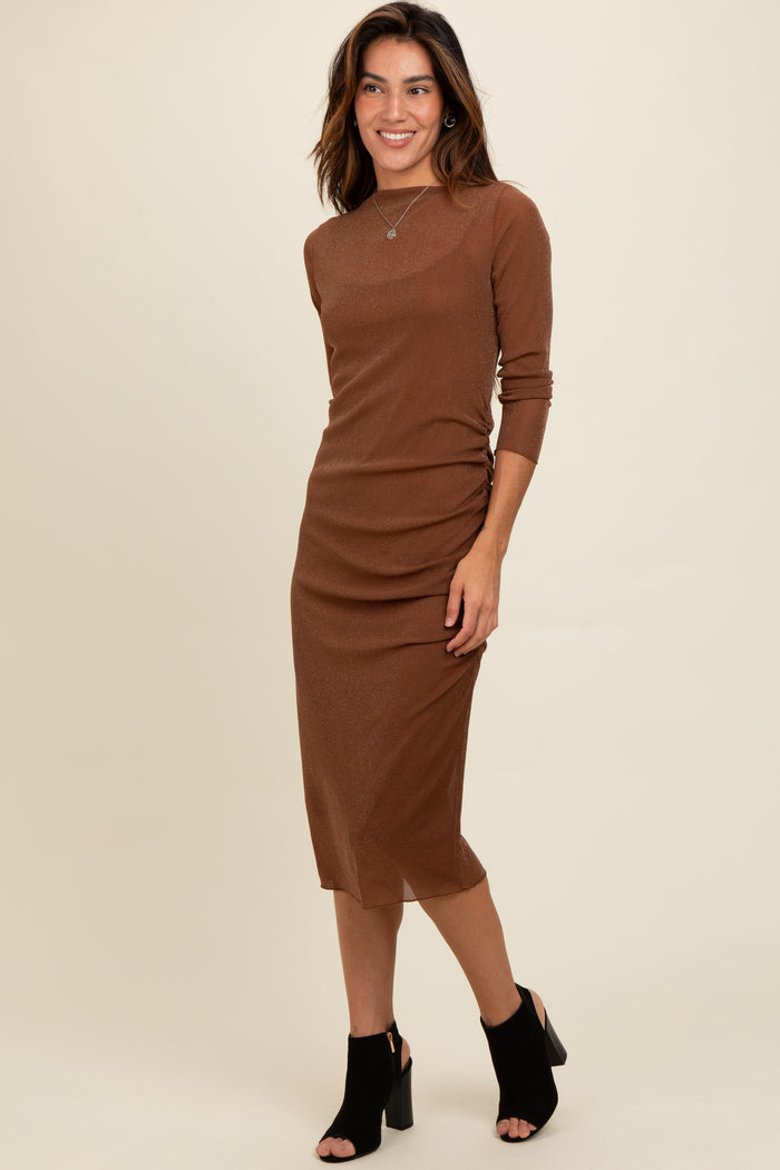 woman wearing a brown long sleeve ribbed midi dress with side ruching and black open-toe heeled shoes