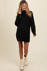 woman wearing a black maternity sweater dress with a high neck and long sleeves, showing a baby bump