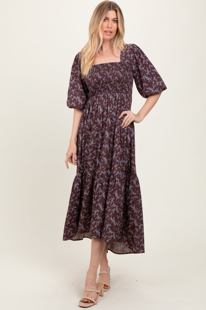woman wearing a dark floral printed maxi dress with a square neckline and puff sleeves