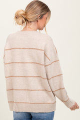 woman wearing a beige striped sweater with a relaxed fit and ribbed hem, seen from the back