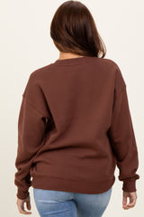 woman wearing a brown oversized sweatshirt with a relaxed fit and long sleeves