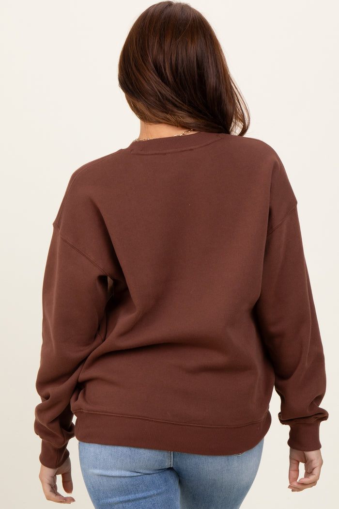 woman wearing a brown oversized sweatshirt with a relaxed fit and long sleeves