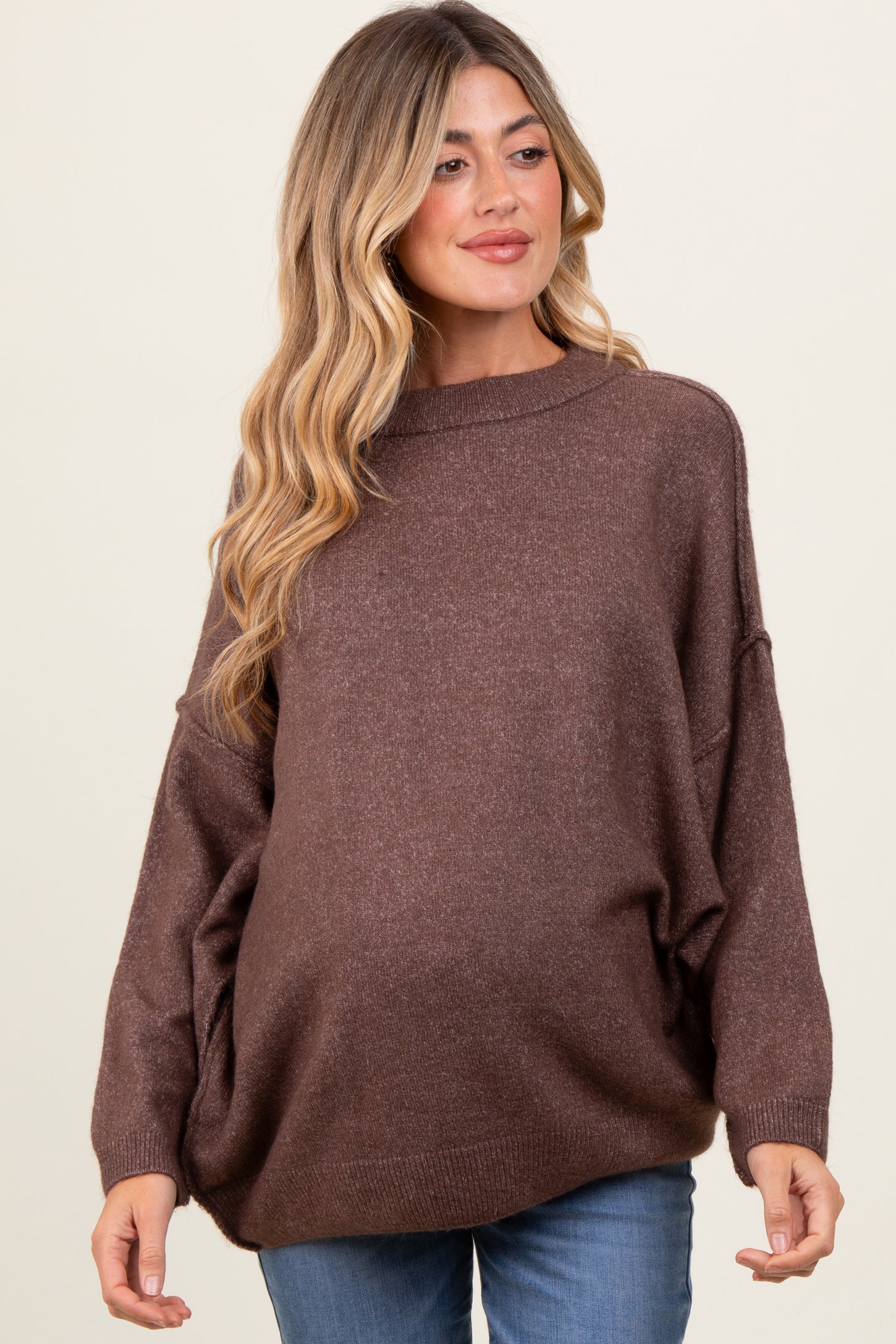 woman wearing a brown oversized maternity sweater with a relaxed fit and a visible baby bump