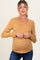 woman wearing a mustard yellow floral long sleeve maternity top and showing her baby bump