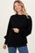 woman wearing a black oversized sweater with long sleeves and a relaxed fit, smiling at the camera