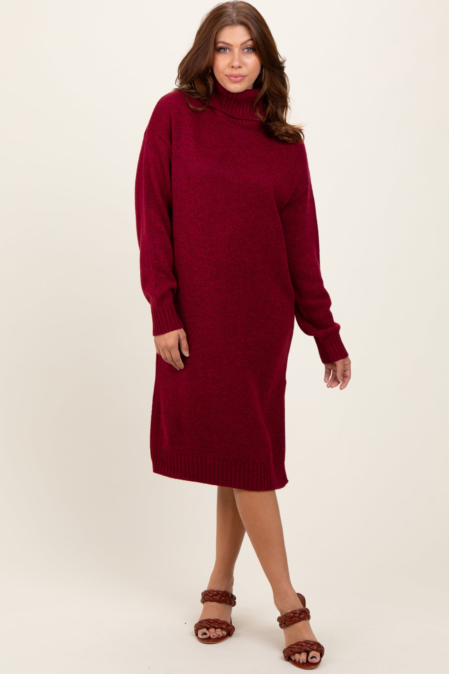 woman wearing a maroon turtleneck sweater dress with long sleeves and a relaxed fit