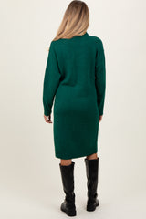 woman wearing a dark green long sleeve sweater dress, featuring a relaxed fit and knee-length, with black knee-high boots