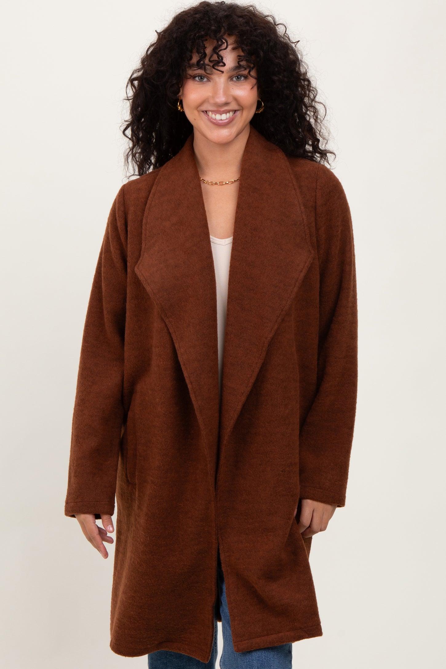 woman wearing a brown oversized cardigan with a shawl collar and long sleeves