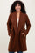 woman wearing a brown long cardigan with an open front and pockets, smiling at the camera
