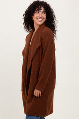 woman wearing a rust-colored long cardigan with an open front and a relaxed fit