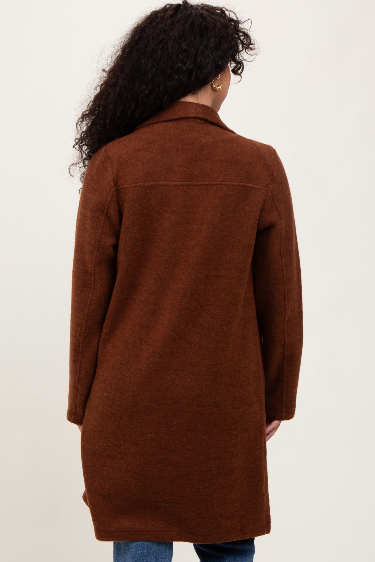 woman wearing a long brown cardigan with a relaxed fit, shown from the back