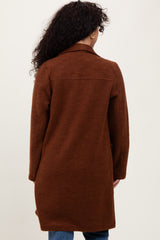 woman wearing a long brown cardigan with a relaxed fit, shown from the back