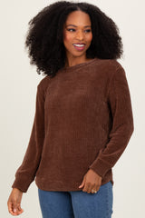 woman wearing a brown ribbed long sleeve sweater with a relaxed fit and side slits, smiling at the camera
