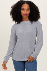 woman wearing a gray long sleeve waffle knit sweater paired with blue jeans