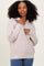 woman wearing a light beige half-zip knit sweater with a relaxed fit and long sleeves, smiling at the camera