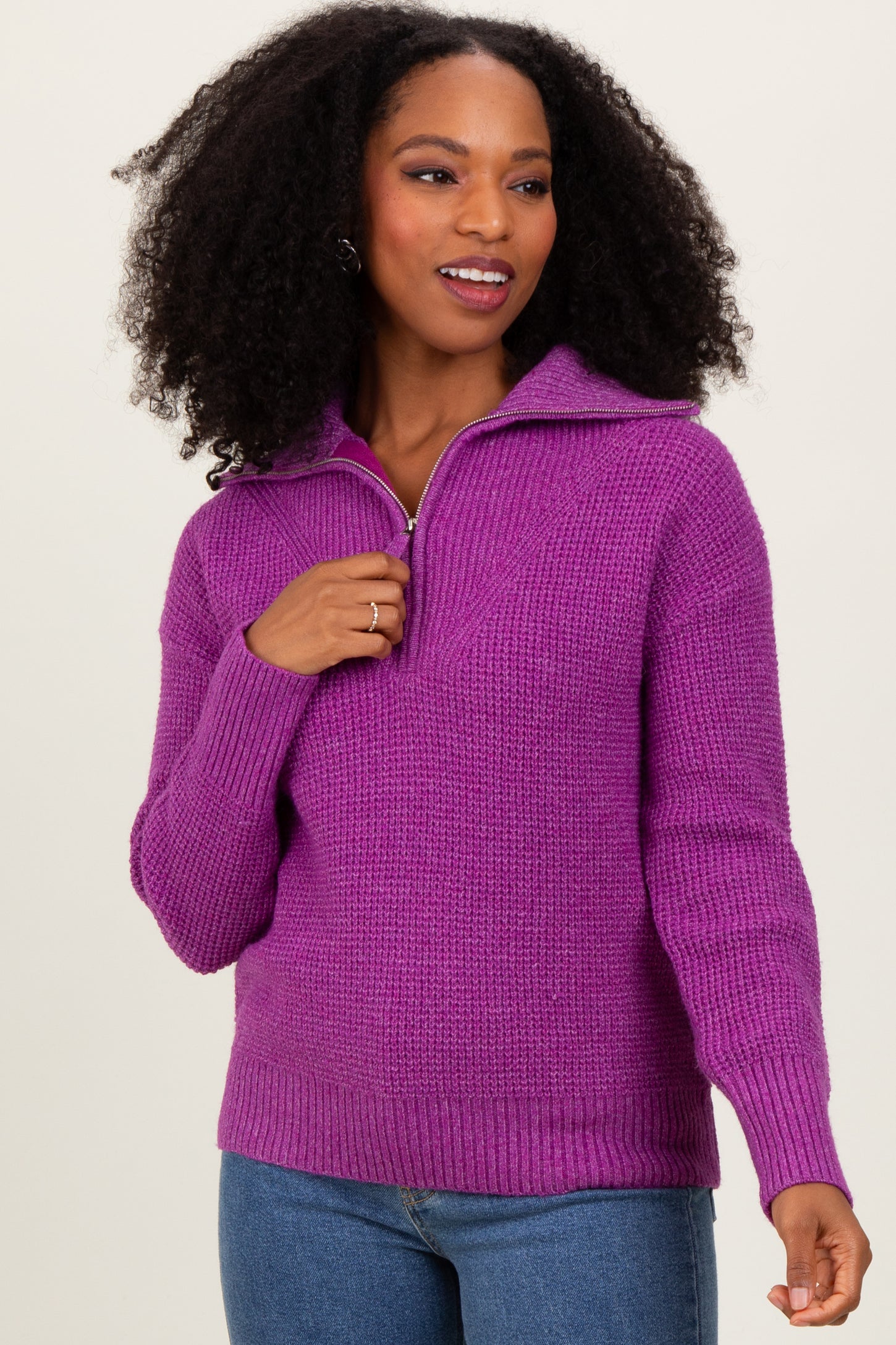 woman wearing a purple zip-up knit sweater with a relaxed fit and ribbed cuffs