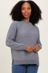 woman wearing a gray long sleeve sweater with side slits and ribbed hem, styled with blue jeans