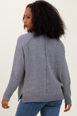 woman wearing a gray knit cardigan with a back seam detail and slouchy fit, paired with blue jeans
