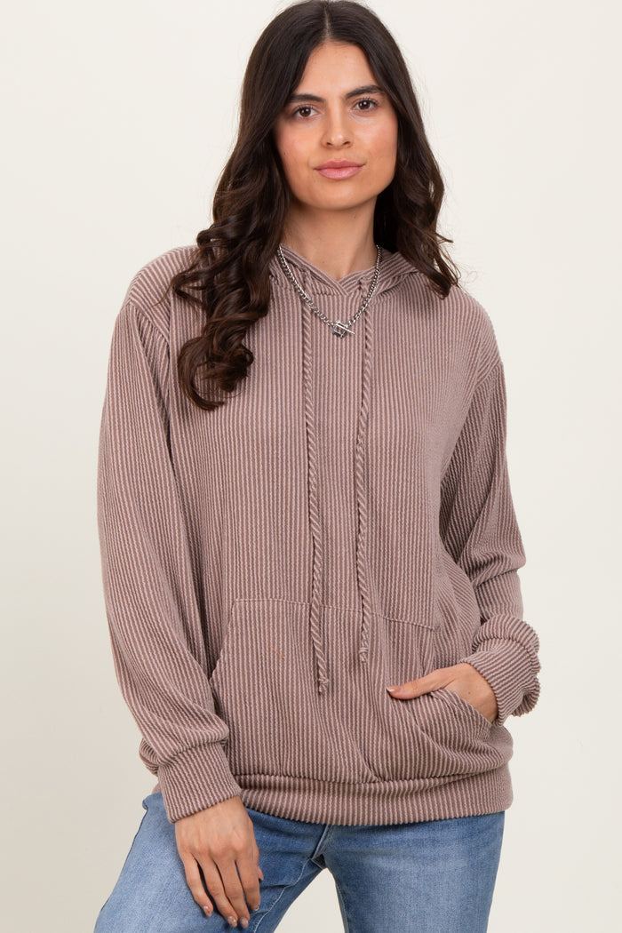 woman wearing a taupe ribbed hooded sweatshirt with a front pocket and drawstring details