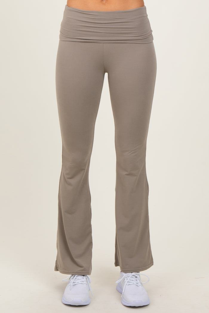 woman wearing light brown flared yoga pants with a wide waistband and white athletic shoes