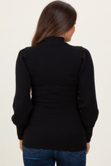 woman wearing a black ribbed maternity top with puff sleeves, viewed from the back