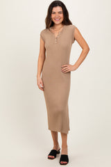 woman wearing a tan ribbed midi dress with cap sleeves and button detailing, standing with one hand on her hip