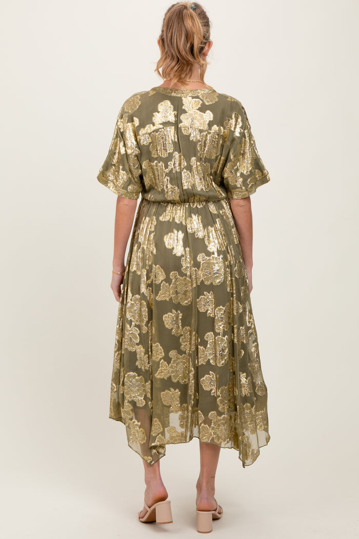 woman wearing a green floral maternity dress with gold detailing and a flowy hem, viewed from the back