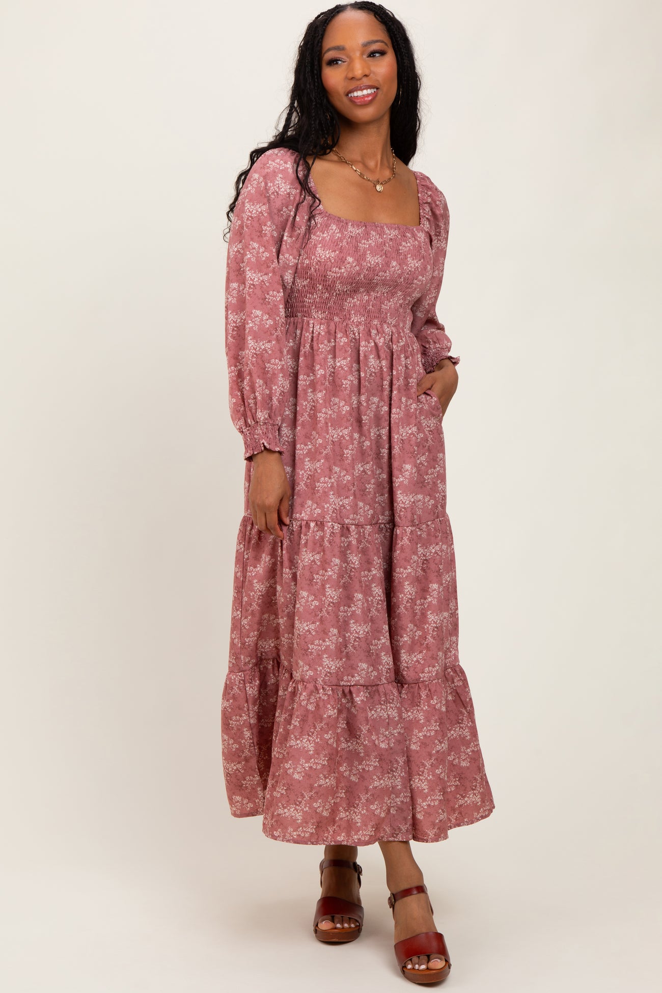 woman wearing a mauve floral long sleeve maxi dress with a square neckline and tiered ruffle hem
