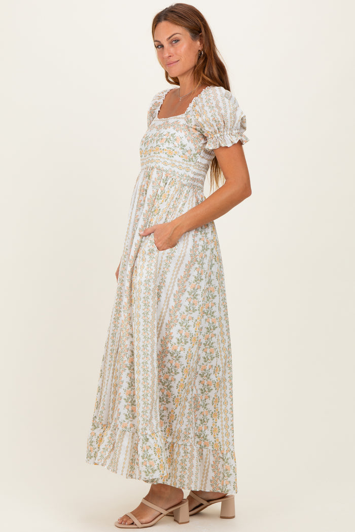 woman wearing a white floral maxi dress with puff sleeves and pockets