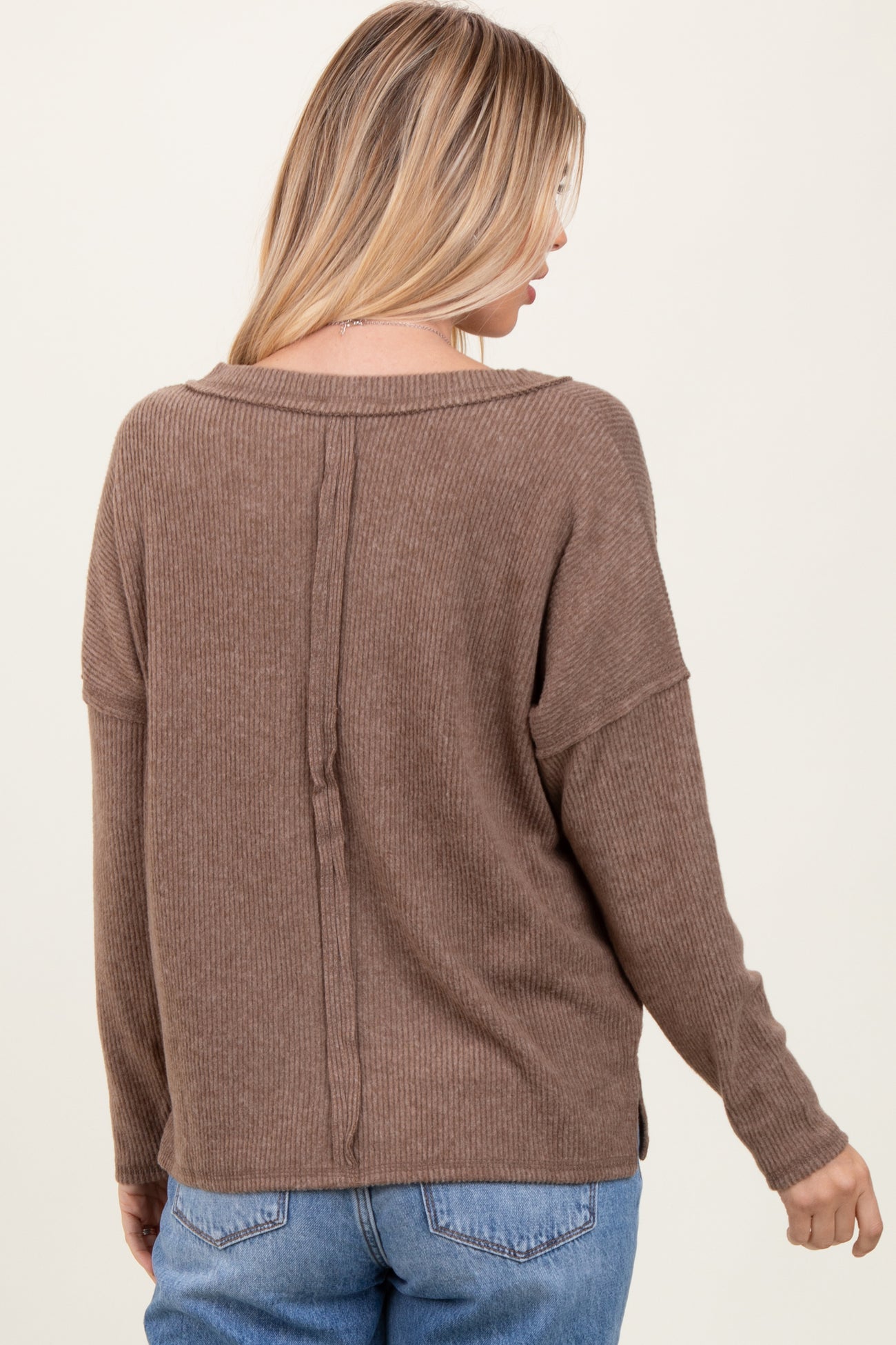woman wearing a cozy brown ribbed knit sweater with a relaxed fit and back seam detail