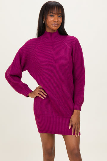 woman wearing a fuchsia ribbed sweater dress with long sleeves and a high neckline