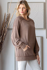 woman wearing a brown ribbed long sleeve oversized sweater with pouch pockets and relaxed fit