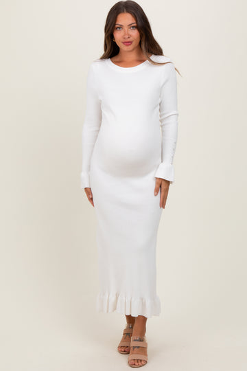 woman wearing a white ribbed maternity dress with long sleeves and frill hem, showing baby bump