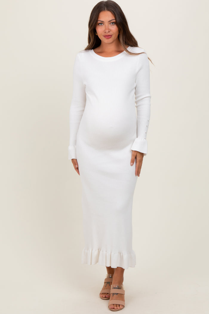 woman wearing a white ribbed maternity dress with long sleeves and frill hem, showing baby bump