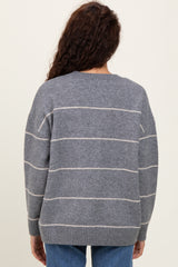 woman wearing a gray striped oversized sweater with a soft knit texture, viewed from the back
