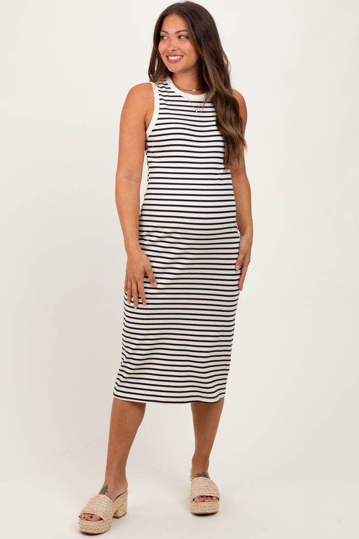 woman wearing a black and white striped maternity tank dress, standing and smiling, with a fitted silhouette