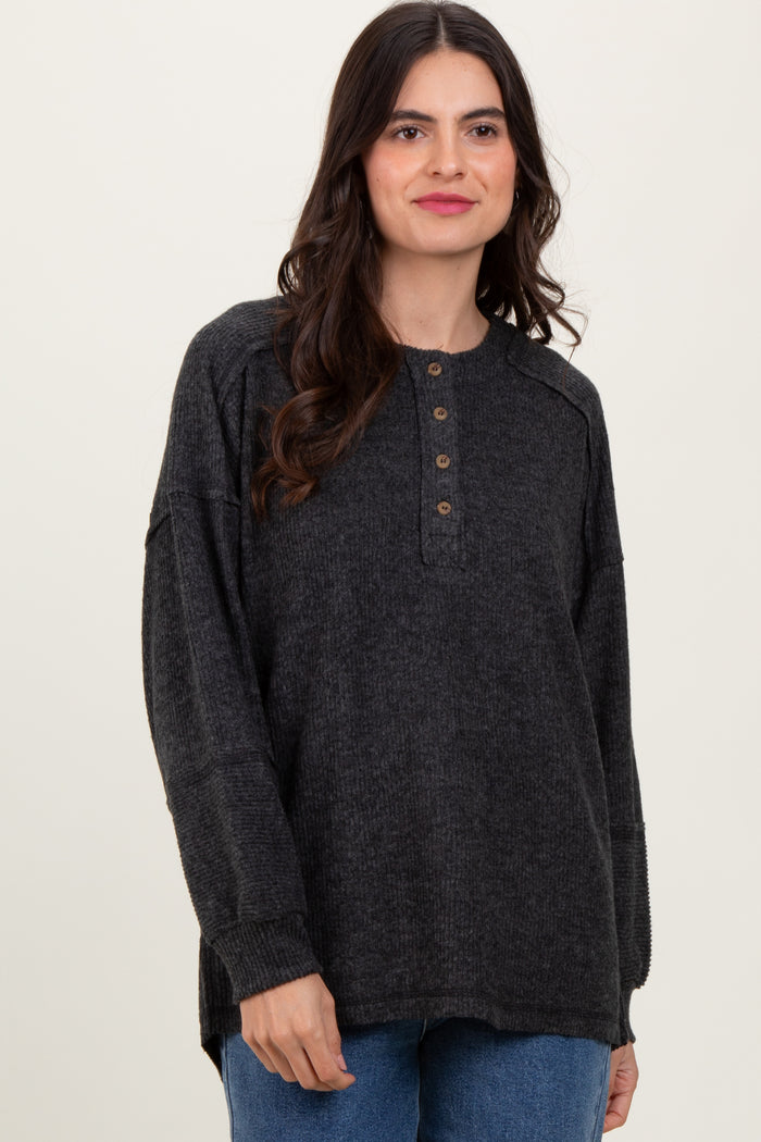 woman wearing a charcoal gray long sleeve henley top with button details and relaxed fit