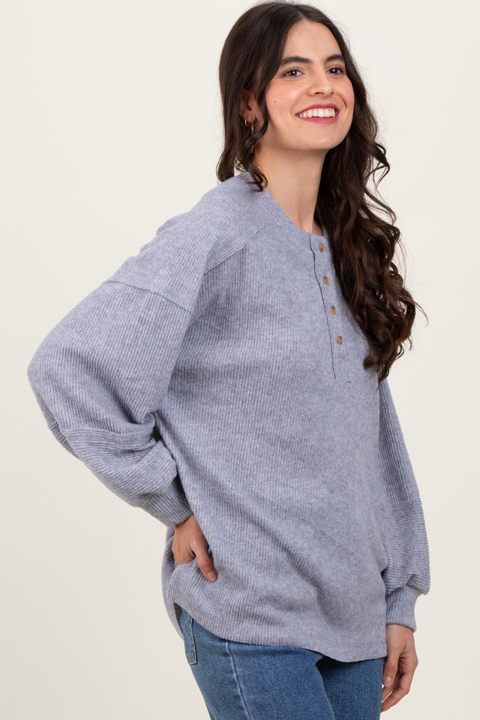 woman wearing a gray ribbed long sleeve henley top with buttons and relaxed fit