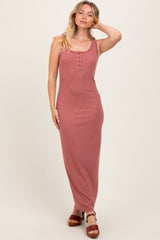 woman wearing a striped red and pink maxi dress with buttons at the neckline and strappy sandals