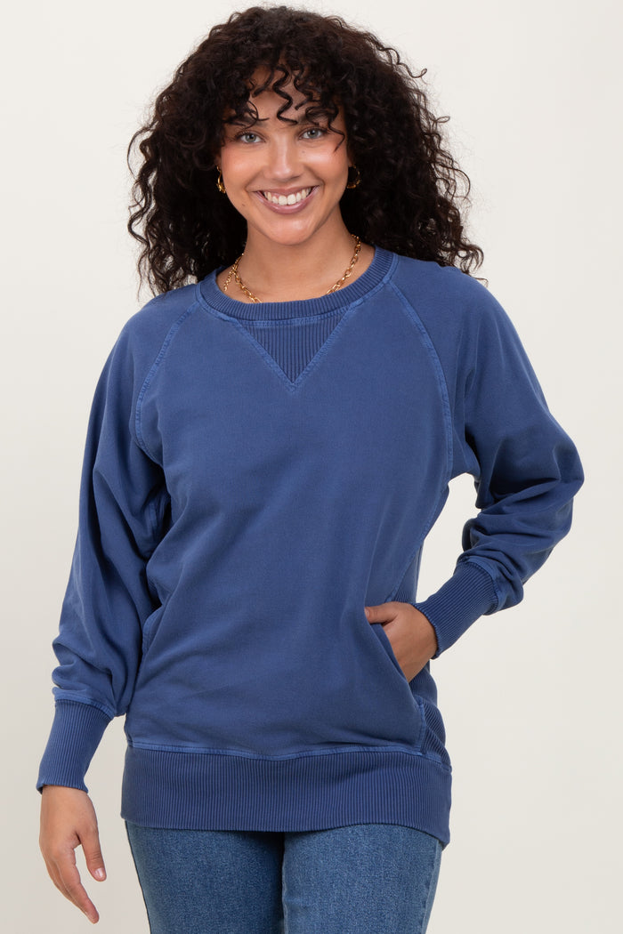 woman wearing a navy blue oversized sweatshirt with raglan sleeves and a rounded neckline