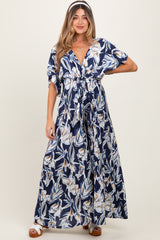 woman wearing a navy floral maxi maternity dress with a tie front and short sleeves, showing her baby bump